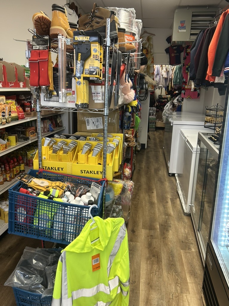 Groceries, work gear, and clothing along the aisle inside Guallpa Latin Market